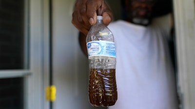 Toney Lewis shows a bottle of tap water he saved, before his neighborhood was recently switched to the current Ferriday, La. water system, in Ridgecrest, La., Tuesday, Sept. 13, 2022.