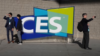People take pictures in front of a sign during the CES tech show on Jan. 6, 2022, in Las Vegas. CES is returning to Las Vegas in January 2023 with the hope that it inches closer to how it looked before the pandemic.