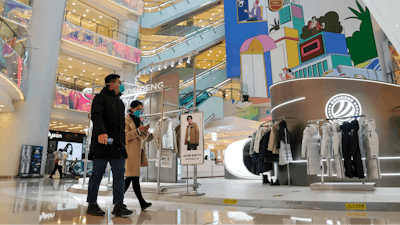 Shoppers walk through a reopened shopping mall after authorities started easing some of the anti-virus controls in Beijing on Dec. 6, 2022.