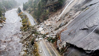 Rocks and vegetation cover Highway 70 following a landslide in the Dixie Fire zone, Plumas County, Calif., Oct. 24, 2021.