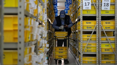 A worker collects parts at SMC, a Japanese pneumatic engineering company factory in Beijing on Jan. 10, 2023. China's trade surplus swelled to a record $877.6 billion in 2022 as exports rose 7% despite weakening U.S. and European demand and anti-virus controls that temporarily shut down Shanghai and other industrial centers.
