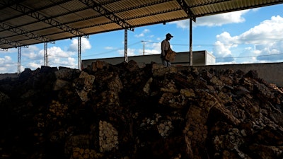 A worker transports a slab of raw rubber at a rubber industrial plant of the cooperative called Cooperacre, in Sena Madureira, Acre state, Brazil, Friday, Dec. 9, 2022.