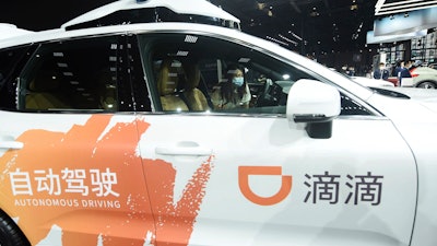 A visitor checks an autonomous car developed by Didi at an auto show in Shanghai, China on April 19, 2021.