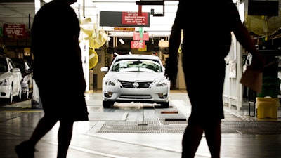 Workers at the Nissan plant in Smyrna, Tenn., walk by a Nissan Altima sedan on May 15, 2012.