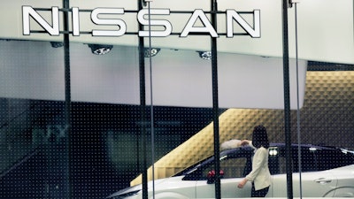 A staff of Nissan car showroom wipes a car on Jan. 31, 2022, in Tokyo.