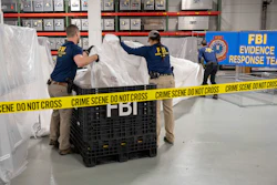 In this image provided by the FBI, FBI special agents assigned to the evidence response team process material recovered from the high altitude balloon recovered off the coast of South Carolina, Thursday, Feb. 9, 2023, at the FBI laboratory in Quantico, Va.