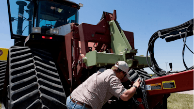 Farmer Nathan Weathers configures a high-power, high-tech quad-track tractor near his farm in Yuma, Colo., June 30, 2008.