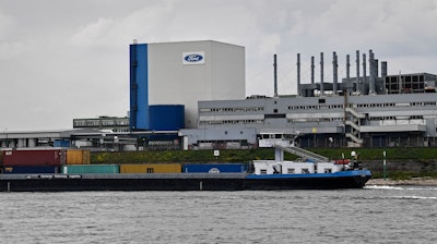 A container ship passes the Ford car plant in Cologne, Germany, May 4, 2020.