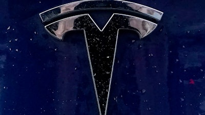 A Tesla electric vehicle emblem is affixed to a passenger vehicle Sunday, Feb. 21, 2021, in Boston.