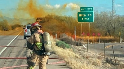 In this photo provided by the Tucson Fire Department, personnel work to control the hazardous material leak and brush fire incidents at Rita Rd. and Interstate 10 near Tucson, Ariz., Tuesday, Feb. 14, 2023.
