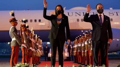 Vice President Kamala Harris and Guatemala's Minister of Foreign Affairs Pedro Brolo wave at her arrival ceremony in Guatemala City, Sunday, June 6, 2021, at the Guatemalan Air Force Central Command.