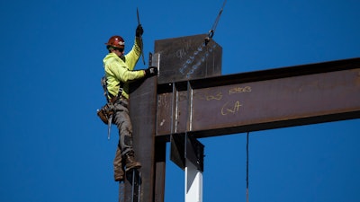 An ironworker guides a beam during construction of a municipal building in Norristown, Pa., Wednesday, Feb. 15, 2023.