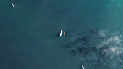 In this satellite photo by Planet Labs PBC, the oil tankers the Oceania, center left, and the Abyss, center right, are seen in the Malacca Strait between Indonesia and Malaysia on Tuesday, March 28, 2023. The Oceania, owned by a major U.S.-traded transportation company, appears to be taking on Iranian crude oil in a key Asian maritime strait in violation of American sanctions, an advocacy group alleges.