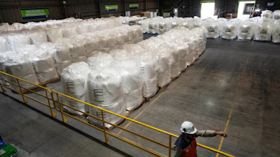 A worker walks next to bags of lithium ready for export at the SQM processing plant in Antofagasta, Chile, Wednesday, April 19, 2023.