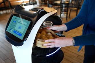 A customer receives a meal delivered by a BellaBot robot at the Noodle Topia restaurant on Monday, March 20, 2023, in Madison Heights, Mich.