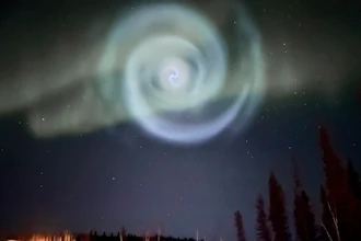 In this photo provided by Christopher Hayden, a light baby blue spiral resembling a galaxy appears amid the aurora for a few minutes in the Alaska skies near Fairbanks, Saturday, April 15, 2023.