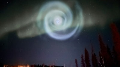 In this photo provided by Christopher Hayden, a light baby blue spiral resembling a galaxy appears amid the aurora for a few minutes in the Alaska skies near Fairbanks, Saturday, April 15, 2023.