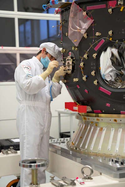 In this photo provided by ispace in April 2023, a technician works on the Hakuto spacecraft in Japan. On Tuesday, April 25, 2023, flight controllers plan to direct the craft to descend from orbit and land on the moon's surface.