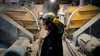 A worker stands beside the mixing machines at the start of a production line creating concrete blocks designed with liquid carbon dioxide as an ingredient at the Glenwood Mason Supply Company, Tuesday, April 18, 2023, in the Brooklyn borough of New York.