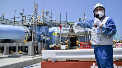 An employee of Tokyo Electric Power Company explains about the facility to be used to release treated radioactive water to media at Fukushima Daiichi nuclear power plant in Fukushima, northern Japan, Monday, June 26, 2023.