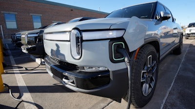 A 2023 R1T pickup truck is charged in a bay at a Rivian delivery and service center Wednesday, Feb. 8, 2023, in Denver.
