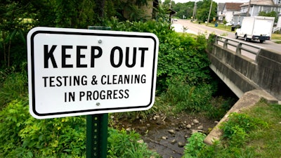 A warning sign is posted near a stream in East Palestine Park in East Palestine, Ohio on Thursday, June 22, 2023.