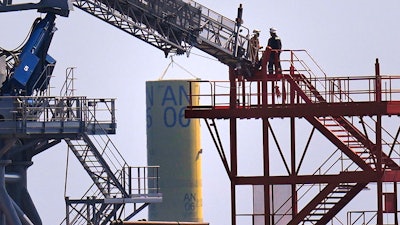 Workers exit a gangway on the C Rambler, an offshore supply ship based in the United States, while working on the South Fork Wind project, Tuesday, July 11, 2023, off the coast of Rhode Island.