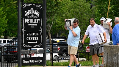 Visitors walk away from the Jack Daniels Distillery visitor center carrying boxes of whiskey Wednesday, June 14, 2023, in Lynchburg, Tenn.