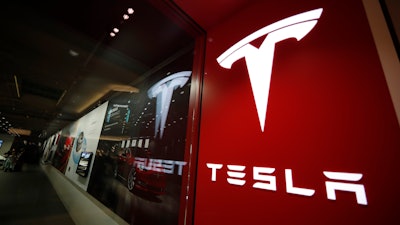 A sign bearing the Tesla company logo is displayed outside a Tesla store in Cherry Creek Mall in Denver, Feb. 9, 2019.