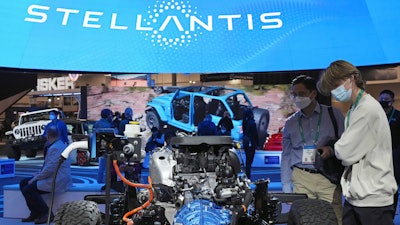 People look at the charging technology from the Jeep Wrangler 4xe at the Stellantis booth during the CES tech show Thursday, Jan. 6, 2022, in Las Vegas.