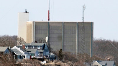 A portion of the Pilgrim Nuclear Power Station is visible beyond houses along the coast of Cape Cod Bay in Plymouth, Mass., March 30, 2011.