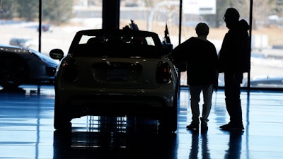 Shoppers consider a 2022 Cooper convertible on display in a Mini dealership in Highlands Ranch, Colo., on Friday, Feb. 18, 2022.