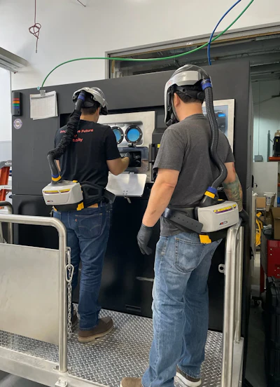 Technicians operating a Velo3D Sapphire AM system at ADDMAN.