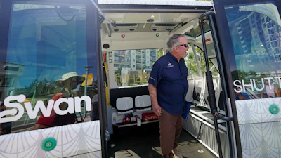 Orlando Mayor Buddy Dyer looks over the new self driving SWAN (Shuttling with Autonomous Navigation) shuttle bus, Wednesday, Aug. 16, 2023, in Orlando, Fla.
