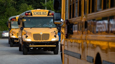 Jefferson County Public Schools buses packed with students make their way through the Detrick Bus Compound on the first day of school, Wednesday, Aug. 9, 2023, in Louisville, Ky.