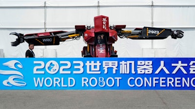 Workers demonstrate a giant robot at the annual World Robot Conference at the Beijing Etrong International Exhibition and Convention Center, Wednesday, Aug. 16, 2023.
