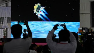 Journalists film the live telecast of spacecraft Chandrayaan-3 landing on the moon at ISRO's Telemetry, Tracking and Command Network facility in Bengaluru, India, Wednesday, Aug. 23, 2023.