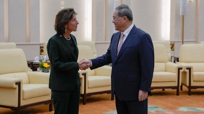 U.S. Commerce Secretary Gina Raimondo, left, is greeted by Chinese Premier Li Qiang at the Great Hall of the People in Beijing, Tuesday, Aug. 29, 2023.