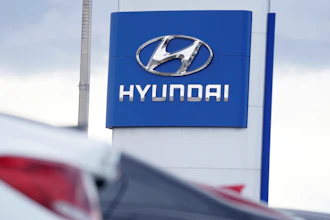 The Hyundai company logo hangs over a long row of cars at a car dealership in Centennial, Colo., Sunday, Dec. 20, 2020.