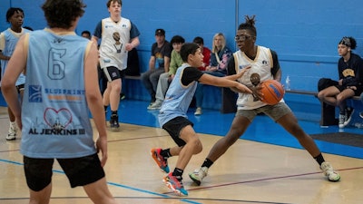 Harris Wolobah, with the basketball in his hands, takes part in game in the Blueprint Basketball League in Worcester, Mass., April 21, 2023.
