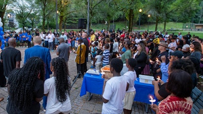 Family and friends hold candles during a vigil for Harris Wolobah in Newton Square Friday, Sept. 8, 2023 in Worcester, Mass.