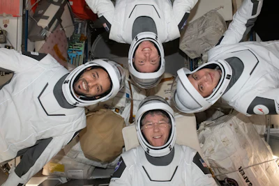 In this May 2023 photo provided by NASA, clockwise from bottom, NASA astronaut Stephen Bowen, United Arab Emirates astronaut Sultan al-Neyadi, NASA astronaut Warren (Woody) Hoburg and Roscosmos cosmonaut Andrei Fedyaev pose for a portrait in their pressure suits aboard the International Space Station.
