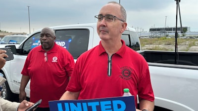 United Auto Workers President Shawn Fain holds up a sign at a union rally held near a Stellantis factory Wednesday, Aug. 23, 2023, in Detroit.