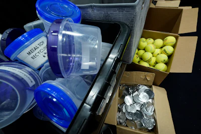 Metal tops from tennis ball container lids, bottom right, are separated for recycling, along with game-used tennis balls, during the U.S. Open tennis championships, Monday, Sept. 4, 2023, in New York. Balls ending up in landfills can take more than 400 years to decompose.