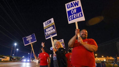 Picketers stand next to a road outside the Stellantis Toledo Assembly Complex early Friday, Sept. 15, 2023, in Toledo, Ohio.