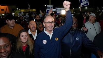 United Auto Workers President Shawn Fain walks with union members striking at Ford's Michigan Assembly Plant in Wayne, Mich., early Friday, Sept. 15, 2023.