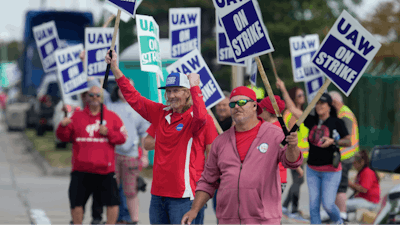 United Auto Workers members walk a picket line during a strike at the Ford Motor Company Michigan Assembly Plant in Wayne, Mich., Friday, Sept. 15, 2023.