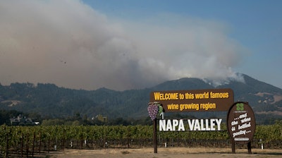 Smoke billows from a fire burning in the mountains over Napa Valley, Friday, Oct. 13, 2017, in Oakville, Calif.