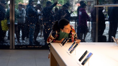 A woman looks at Apple's new iPhone 15 at an Apple Store in Los Angeles, Sept. 22, 2023.