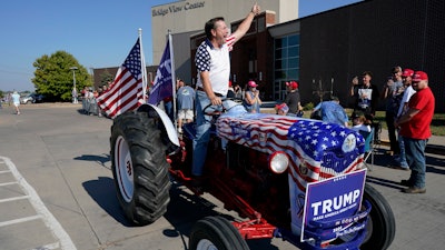 Gary Leffler drives his tractor past supporters before the arrival of former President Donald Trump at a rally, Sunday, Oct. 1, 2023, in Ottumwa, Iowa.